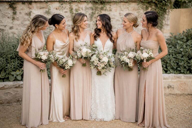Bridal party in nude bridesmaid dresses in soft natural light, showcasing elegant neutral tones and flowing silhouettes