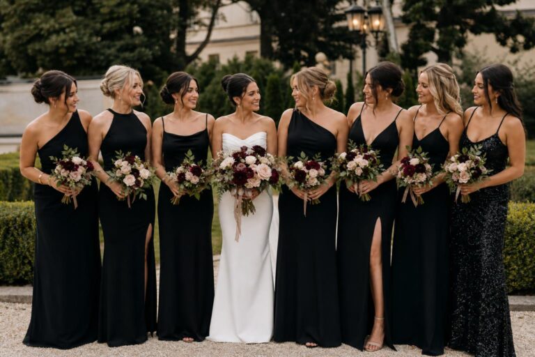 Black bridesmaid dresses mismatched in varied silhouettes and fabrics for a chic, cohesive bridal party photo lineup