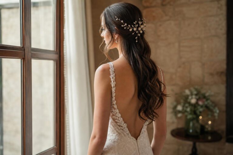 Bridal hairstyles for long hair with soft waves and a pearl hair comb in a romantic wedding portrait