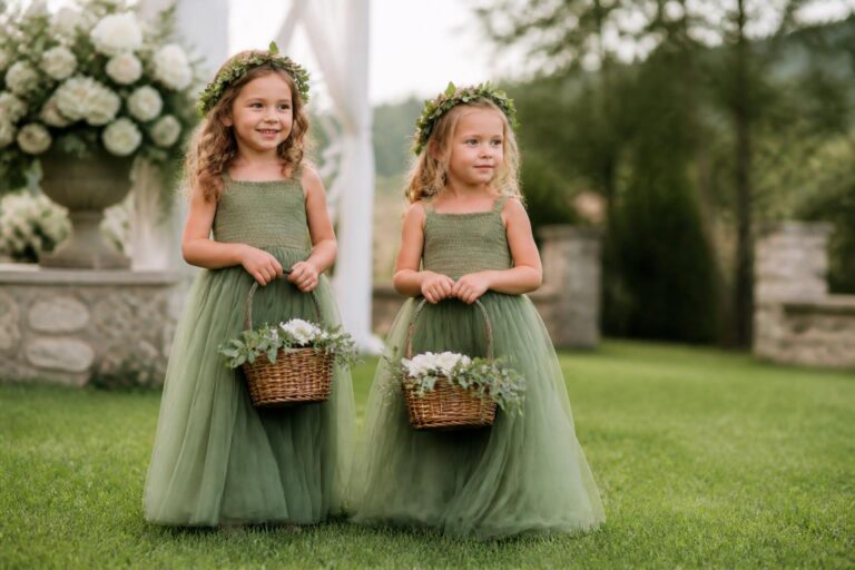 Green flower girl dresses in sage chiffon with tulle skirt, photographed in a romantic garden wedding aisle