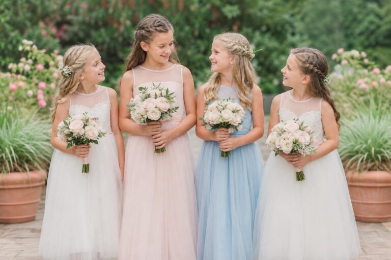 Junior bridesmaid dresses in blush chiffon with soft A-line silhouettes at a romantic garden wedding ceremony