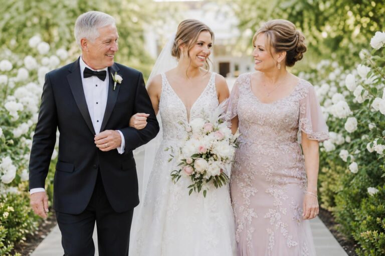 Spring mother of the bride dresses in pastel chiffon with lace sleeves at an outdoor garden wedding ceremony