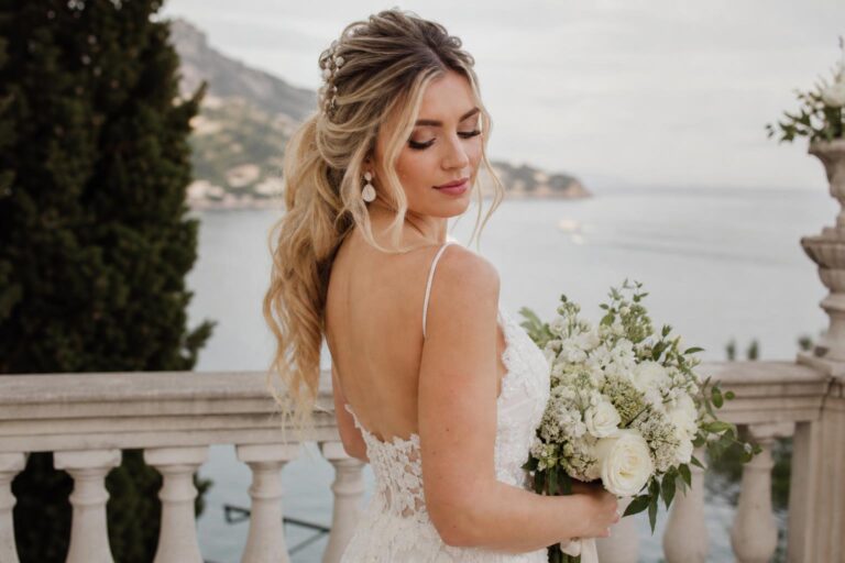 Wedding hairstyles for long hair in a romantic low bun with veil and pearl pins, photographed in soft spring light