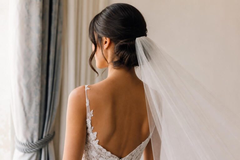 Wedding hairstyles with veil featuring a low chignon and fingertip tulle veil, softly structured for elegant bridal portraits