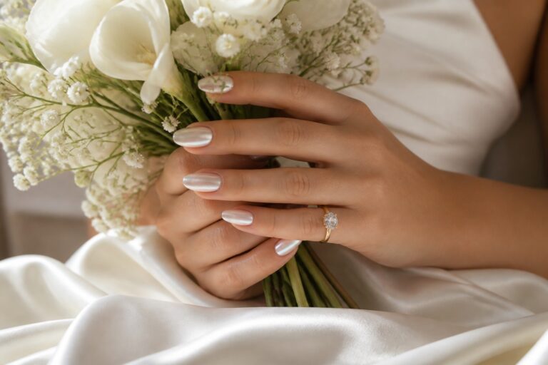 Bride holding a white bouquet with luminous chrome white nails