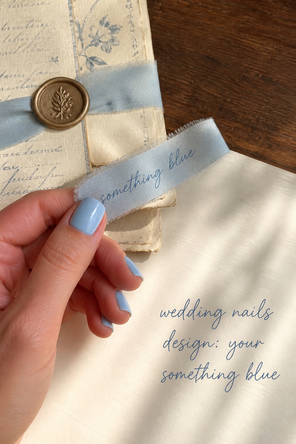 Wedding nails design with pale blue polish and a something blue ribbon